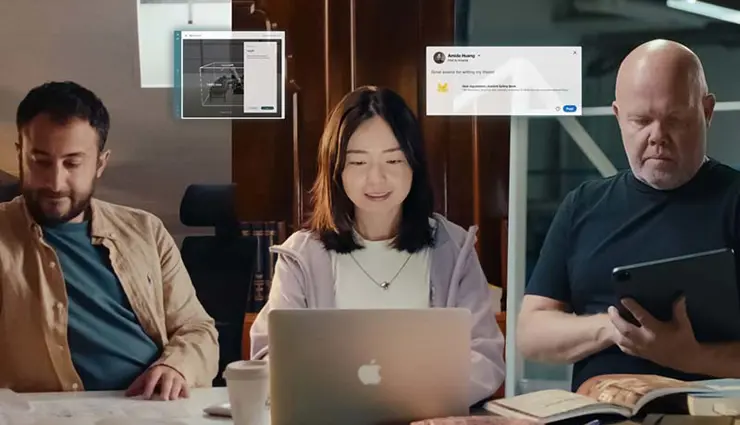 Three people working with laptops, books, and tablets, with digital interface graphics shown above them
