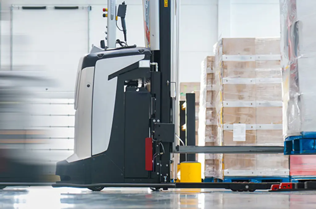 En AGV transporterer en palle i et lager til automatiseret materialehåndtering