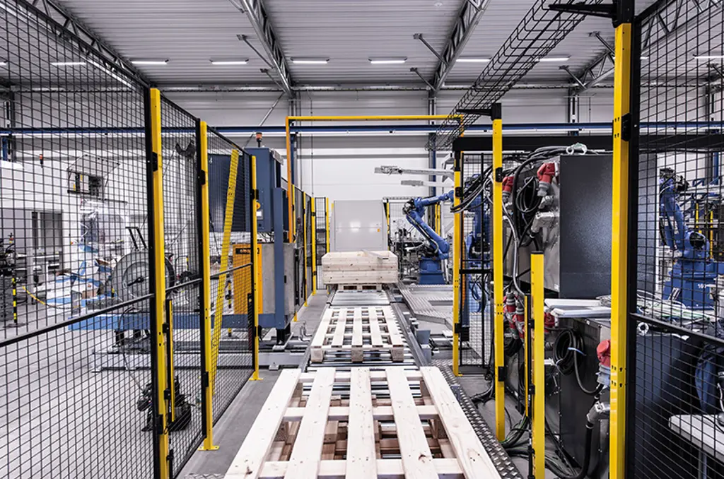 Automatiseret palleteringslinje med robotarme og paller i sikkerhedszone