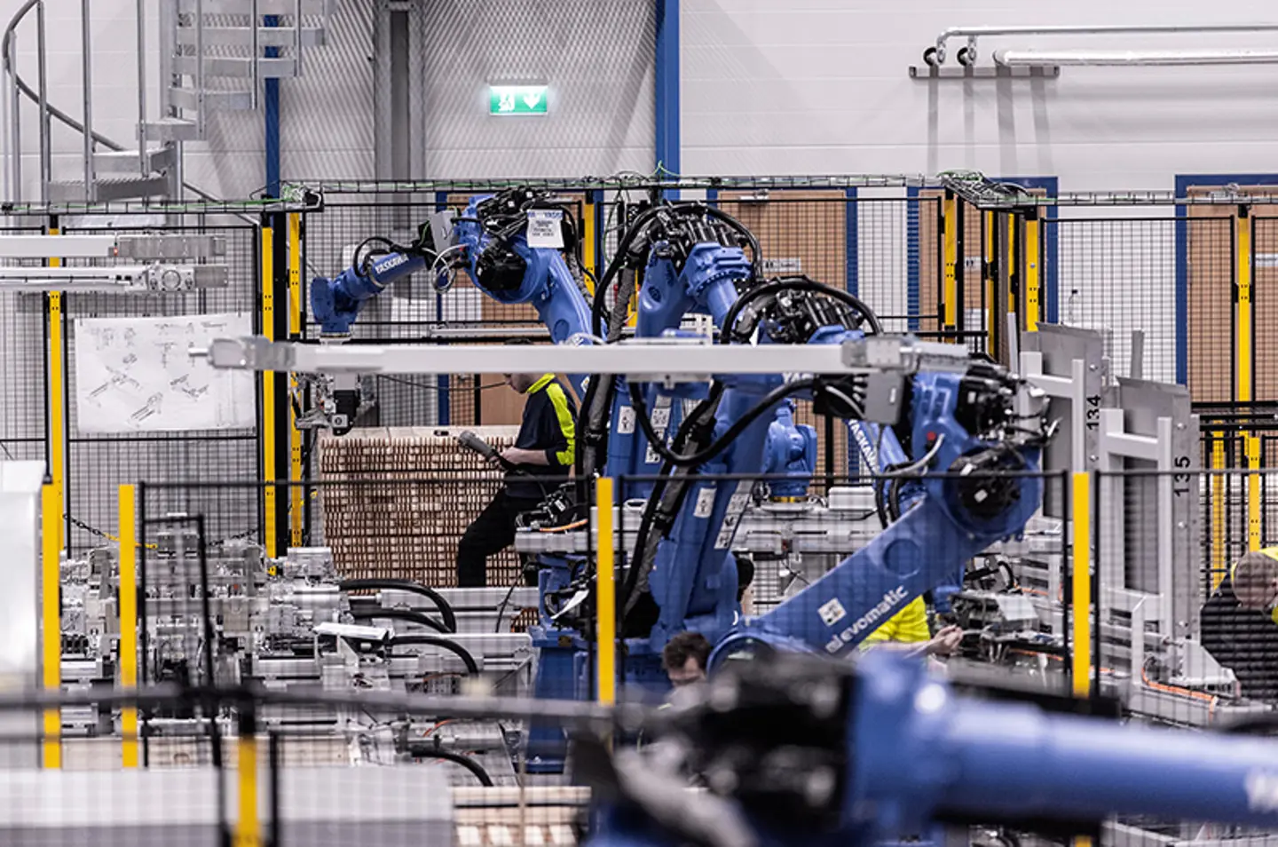 Industrielle robotarme, der palleterer varer inden for en sikret automationscelle
