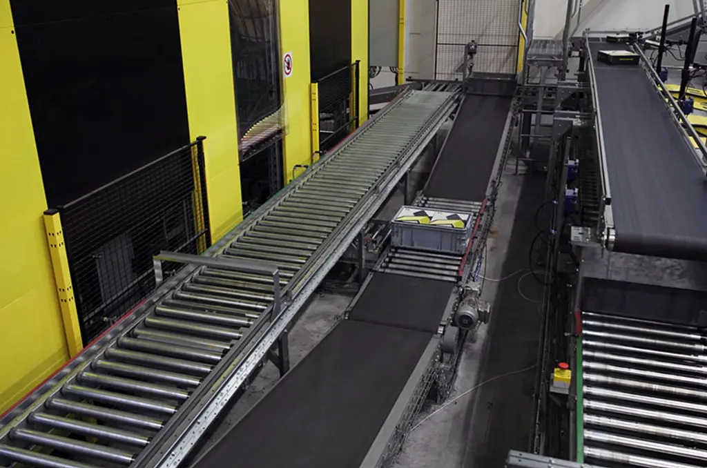 Automatiseret lagersorteringssystem med transportbånd og sikkerhedshegn til højhastighedslogistik